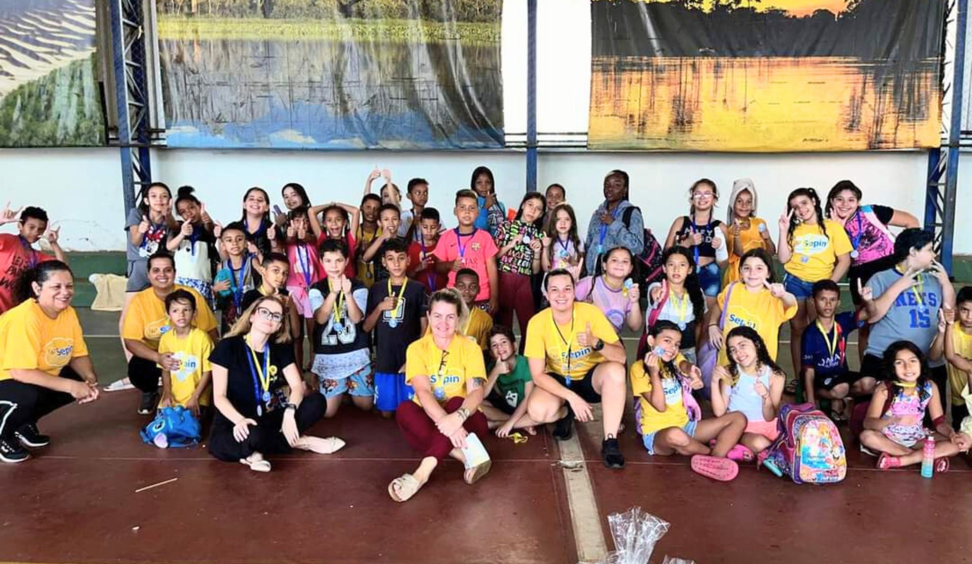 Crianças com medalhas no ginásio do SEPIN